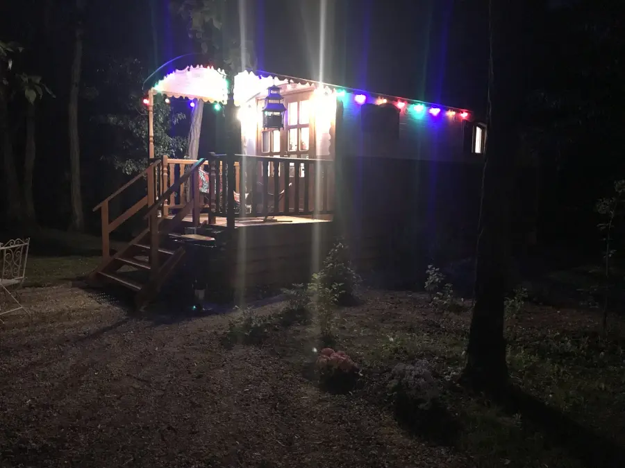 La roulotte illuminée de guirlandes colorées, à la nuit tombée